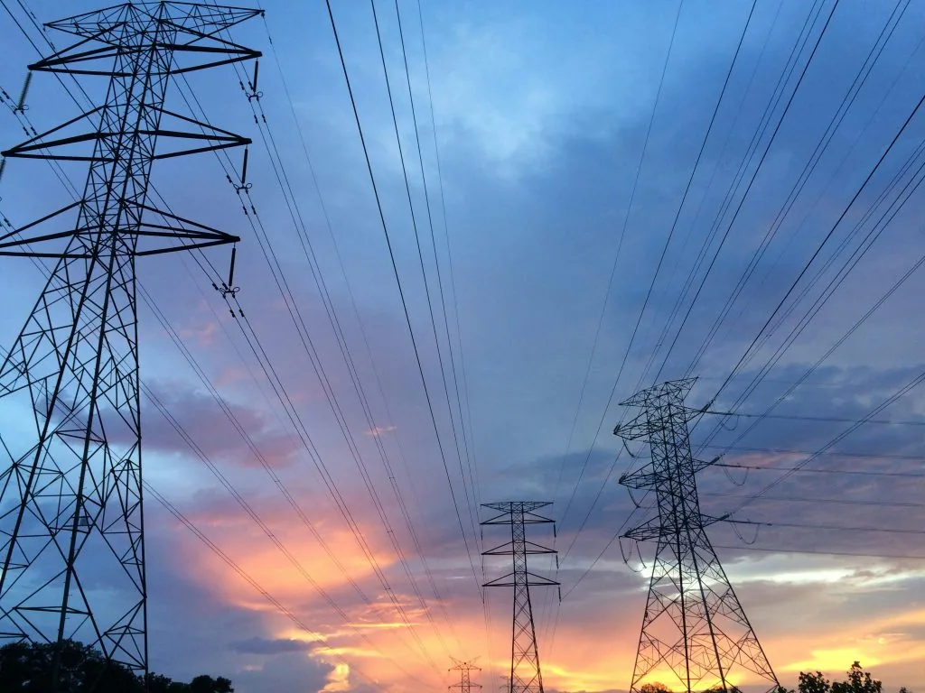 Electrical pylons against a dusk sky.